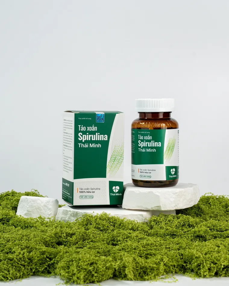 Hộp và lọ Tảo xoắn Spirulina Thái Minh đặt trên nền rêu xanh tự nhiên